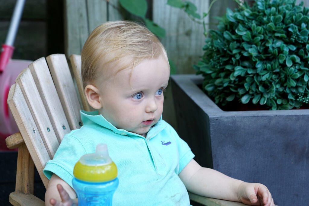 Young boy holding baby bottle