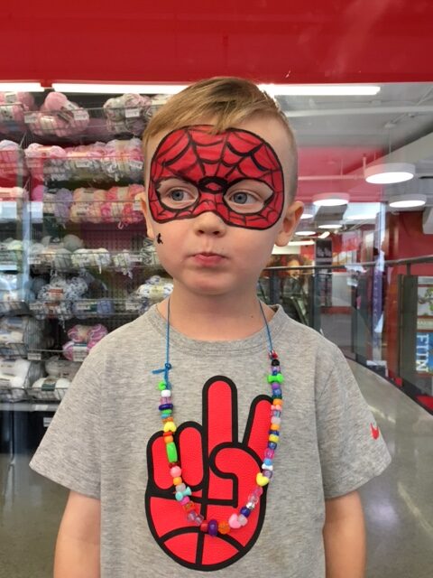 Young boy wearing spiderman mask