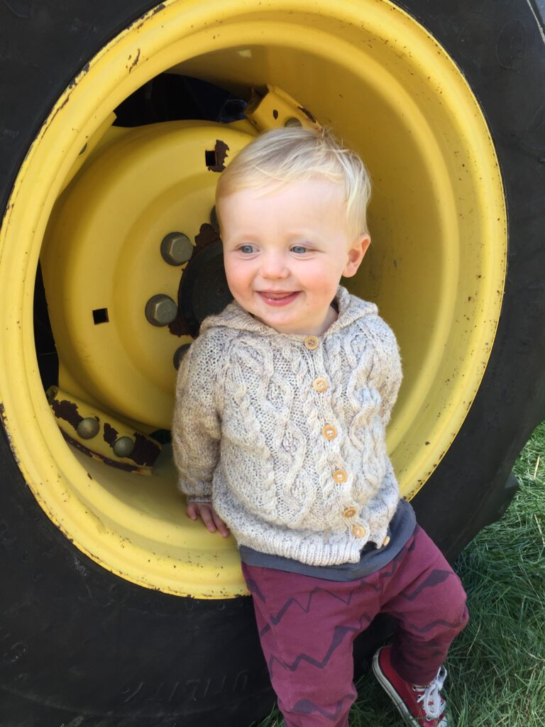 Young boy sitting on a yellow tire