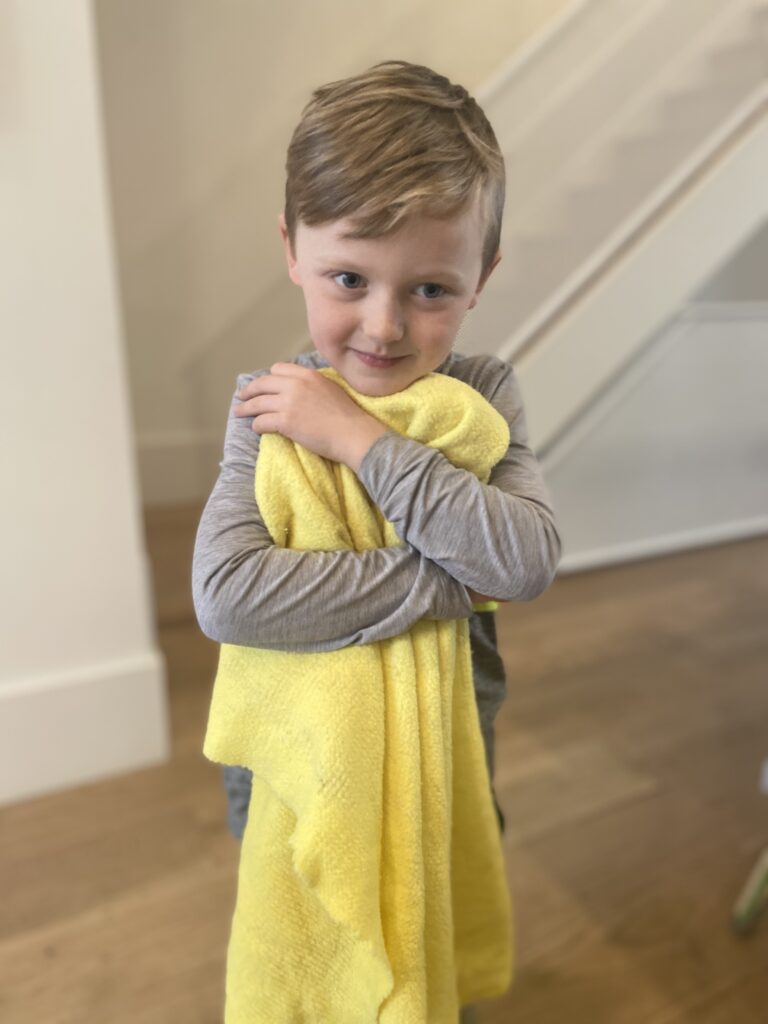 Young boy hugging yellow blanket